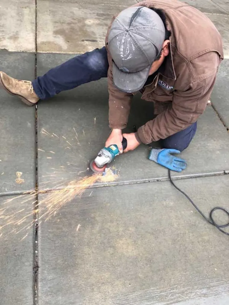 Apollo technician grinding a masonry joint with an angle grinder